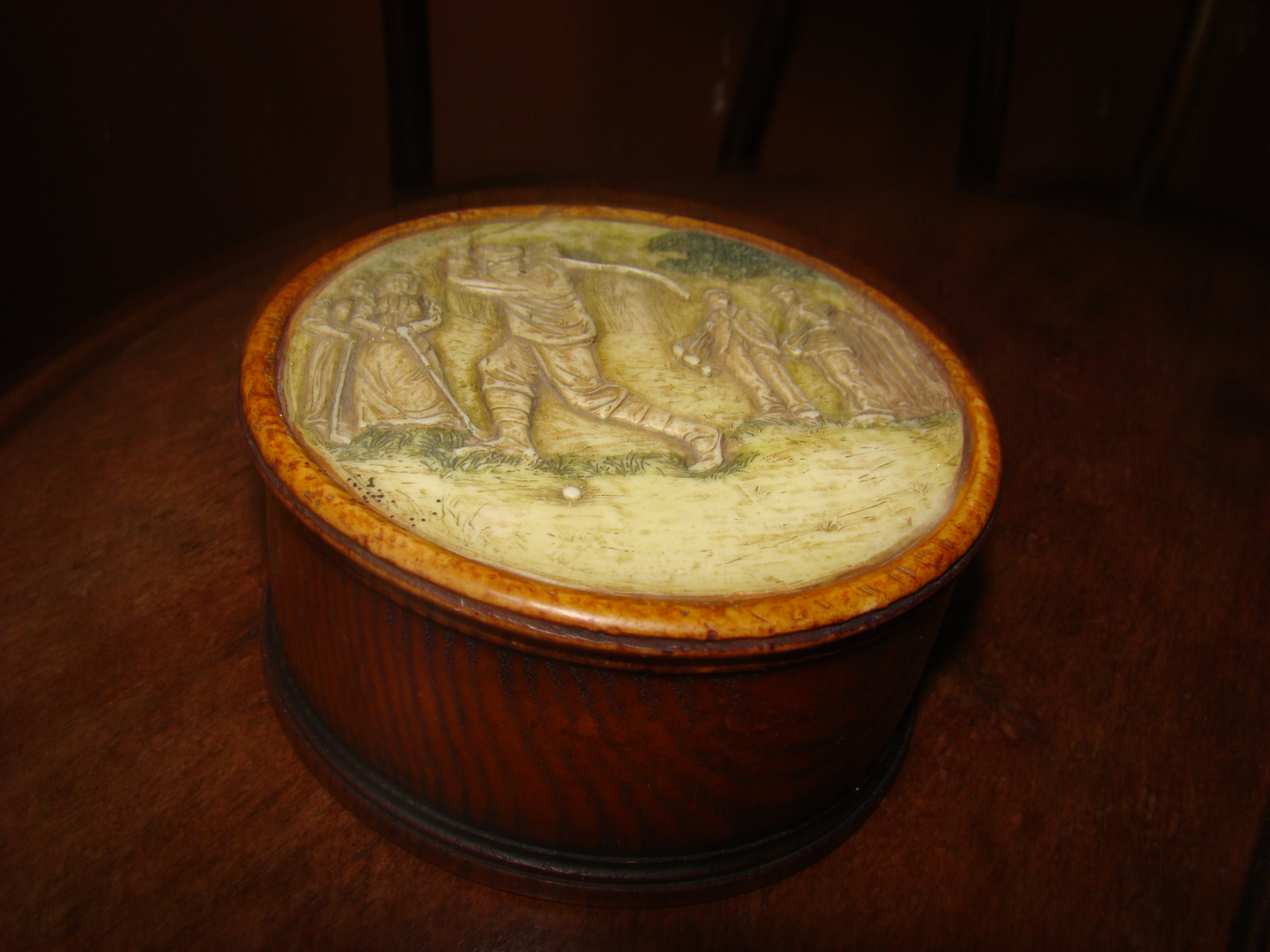 Oud rond stenen dekseldoosje met afbeelding golfers.
