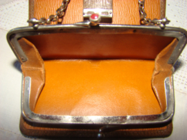 Oude leren portemonnee met rode steentjes en ketting.