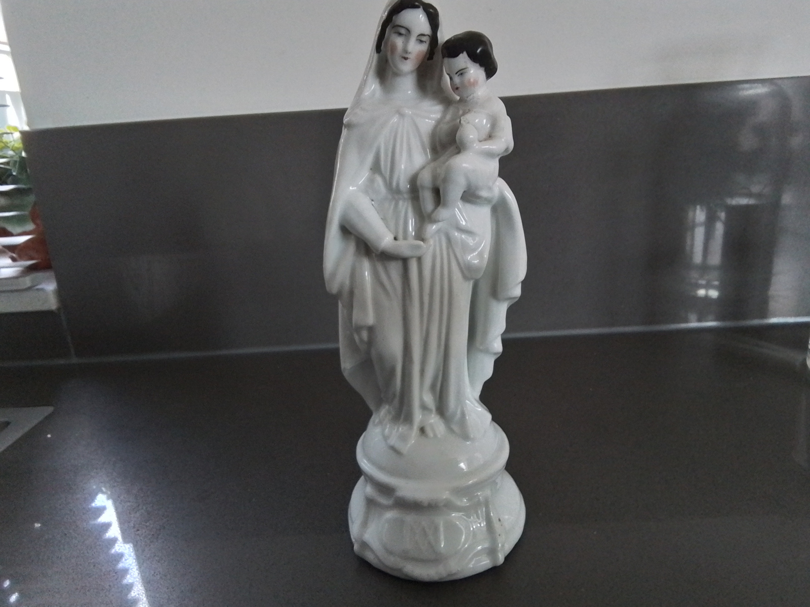 Wit geglazuurd beeld van Maria met het kindje Jezus.
