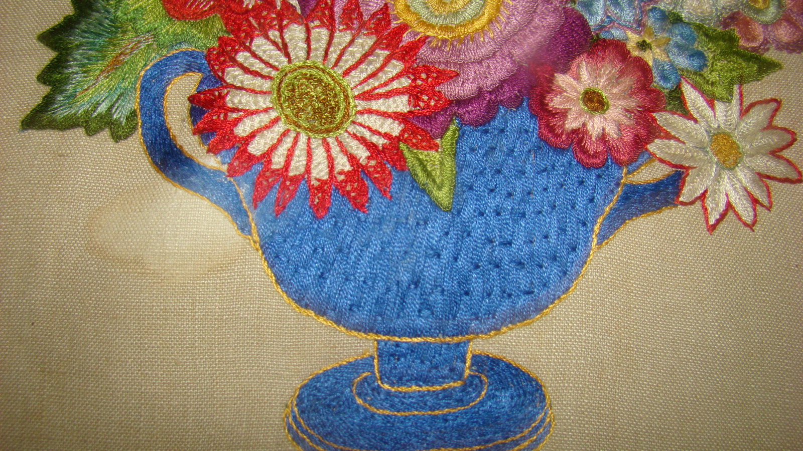 Geborduurde vaas met bloemen op linnen.